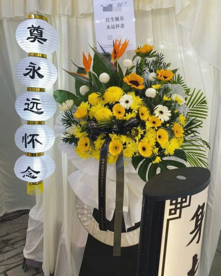 Yellow sunflower and gerbera condolence flower stand in Penang with traditional funeral lanterns