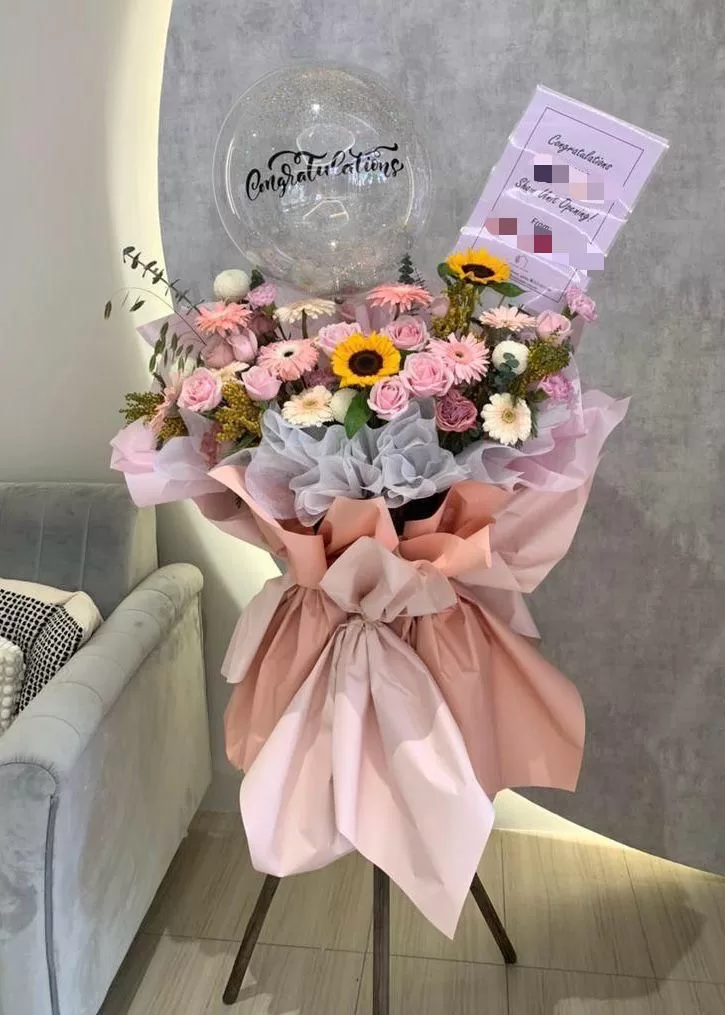 Mixed pink and sunflower grand opening flowers with a congratulations balloon in George Town, Penang