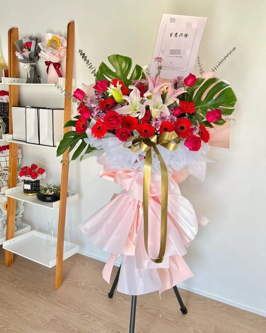 Vibrant red roses and pink lily grand opening flowers on a stand in Penang