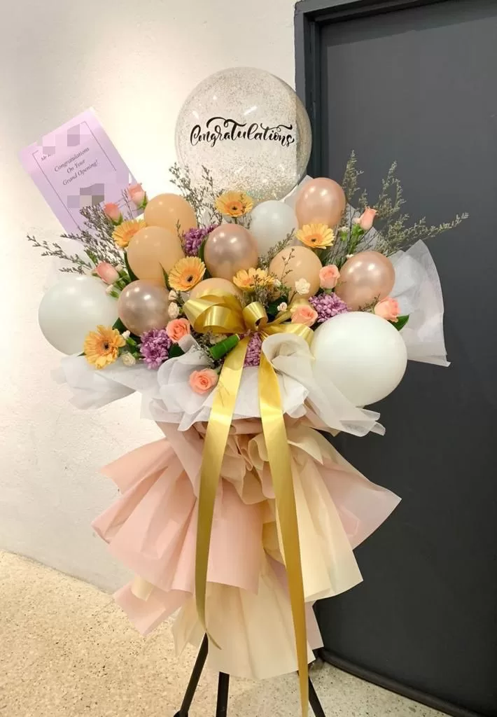 Champagne-colored balloon and gerbera stand from a professional florist in Kulim, Kedah
